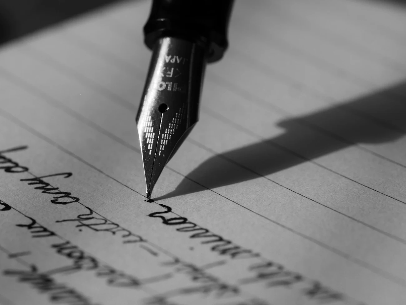 Punta de una pluma estilográfica escribiendo sobre papel
